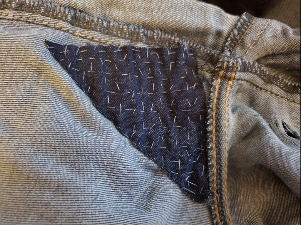 A patch with vertical and horizontal lines of running stitch